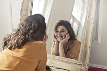 woman yellow facing mirror 2